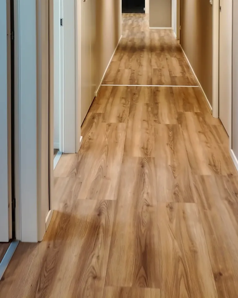 Il corridoio degli ambulatori della clinica di Roncade, col parquet chiaro e le porte grigie