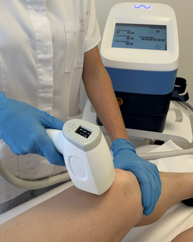 Il laser a diodo in uso: il manipolo sulla gamba e lo schermo dell'apparecchio