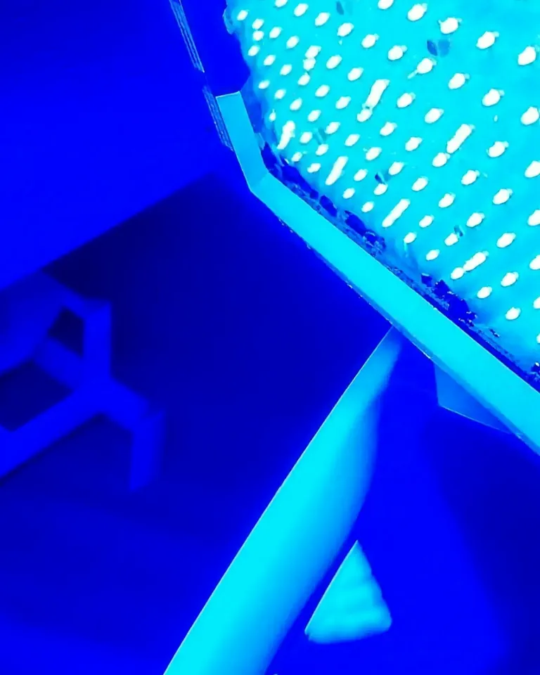Il pannello della luce LED acceso: una griglia di luce blu sopra il lettino